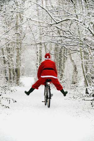 Father Christmas Riding Bicycle in Snowy Woodland Path - Photographic Print, 12x18